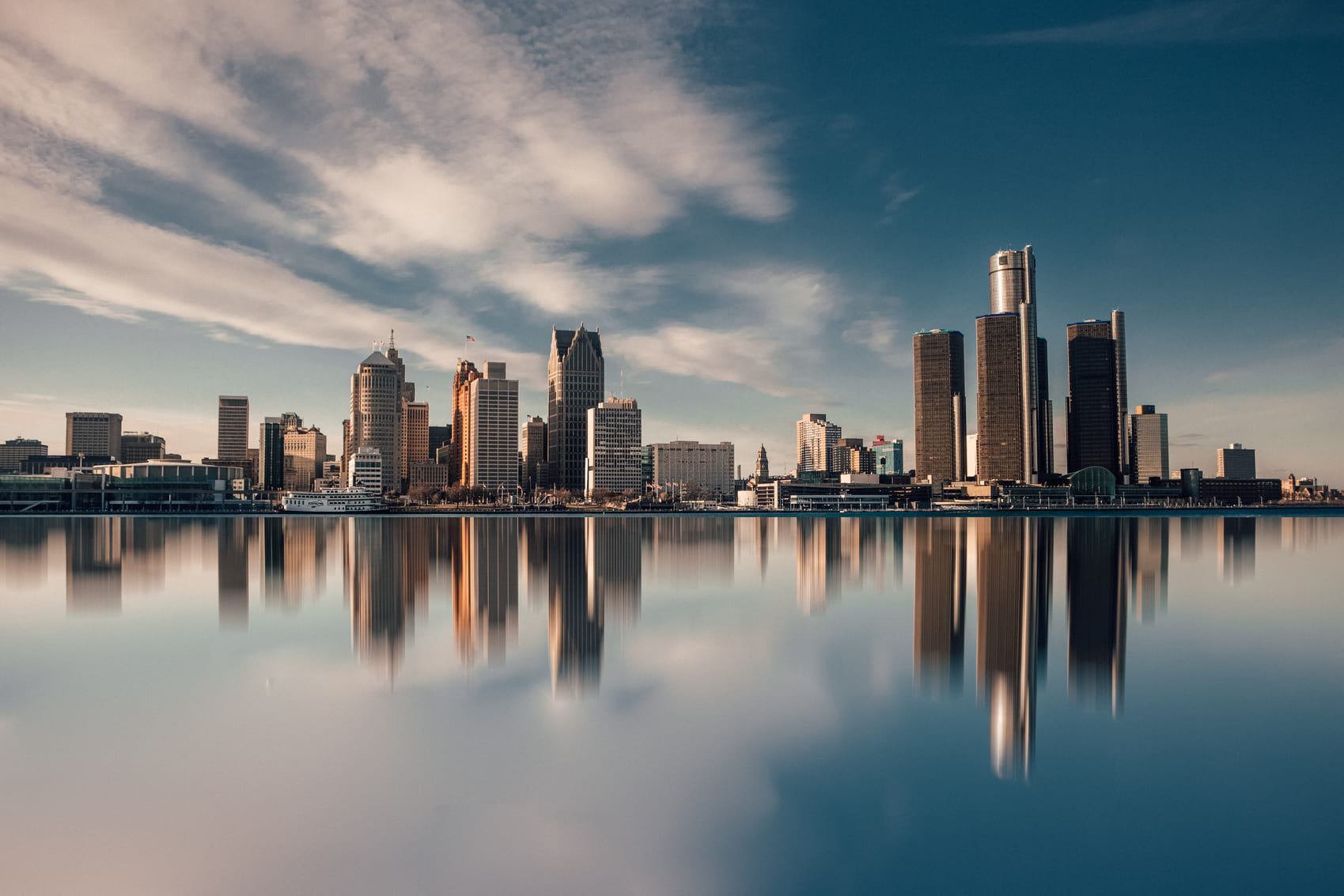 Detroit's skyline during dusk with the reflection of the buildings on the water.